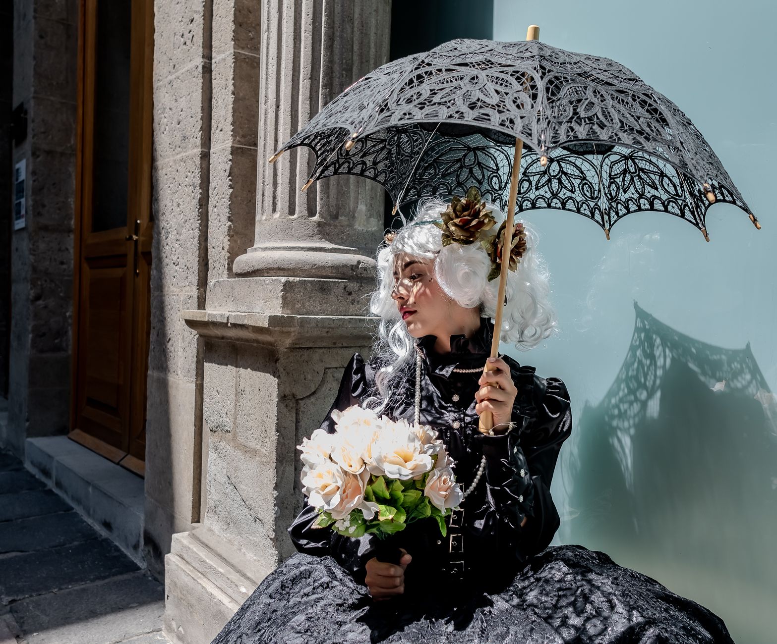 Stylish woman in vintage dress under lace umbrella, Ciudad de México's streets.