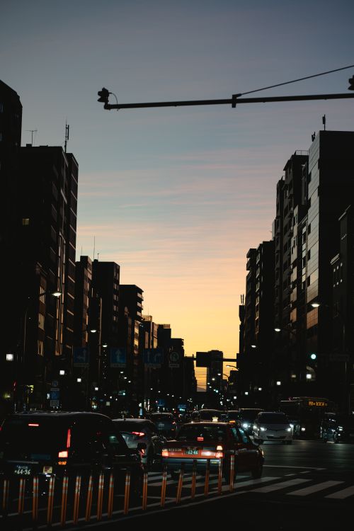 Free Urban cityscape at sunset showcasing heavy traffic and silhouetted buildings against a scenic sky. Stock Photo