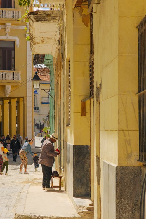 A woman is sitting on a bench in front of a building