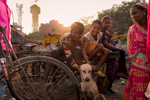 Smiling people with a dog in a slum in India