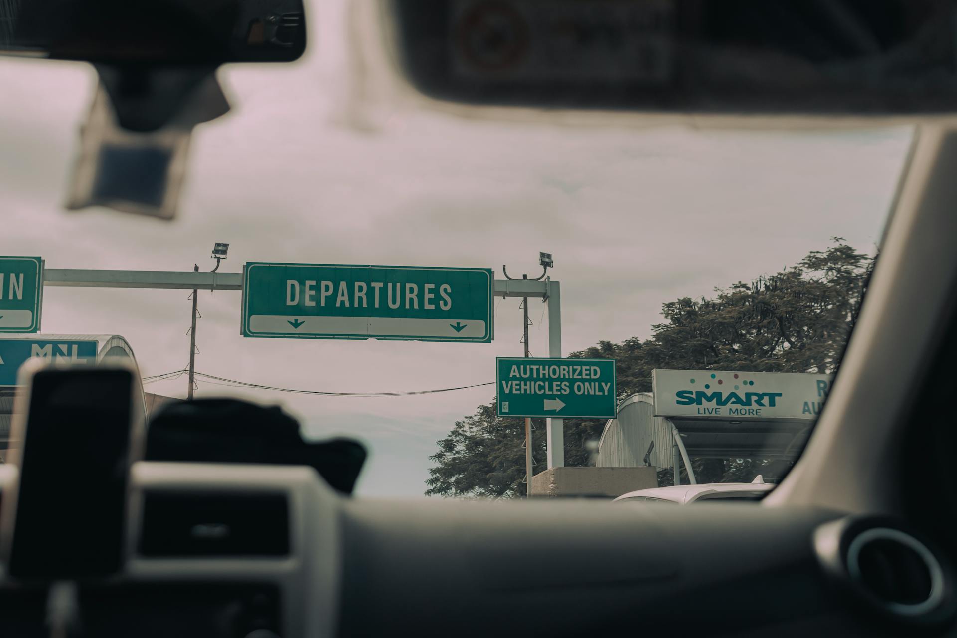 Directional Signs to Airport behind Car Windshield