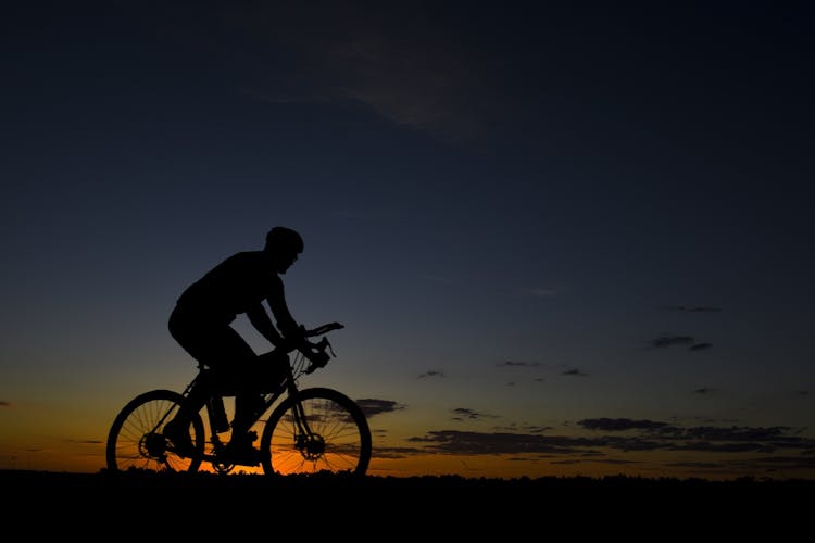 Man Riding Bicycle During Nightfall