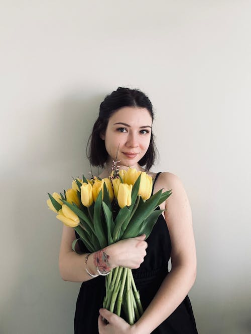 Young Woman Holding a Bunch of Yellow Tulips 