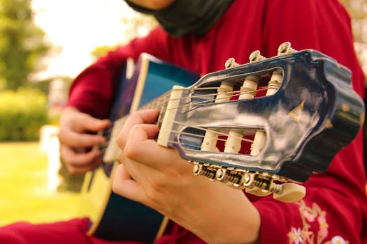 Close-up of a person playing guitar outdoors in İstanbul, Türkiye, showcasing musical passion.