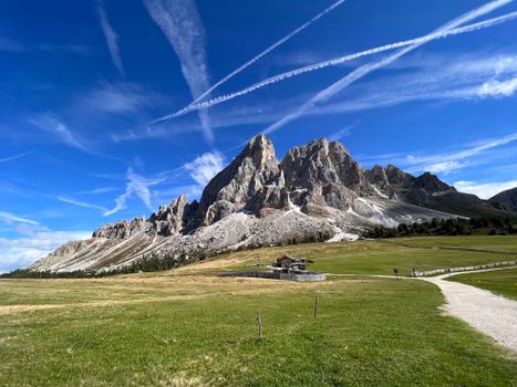 Stunning view of the Dolomites with clear skies and vibrant greenery in San Martino in Badia, Italy.