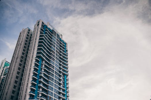 High-rise building with modern architecture reaching into a cloudy sky.