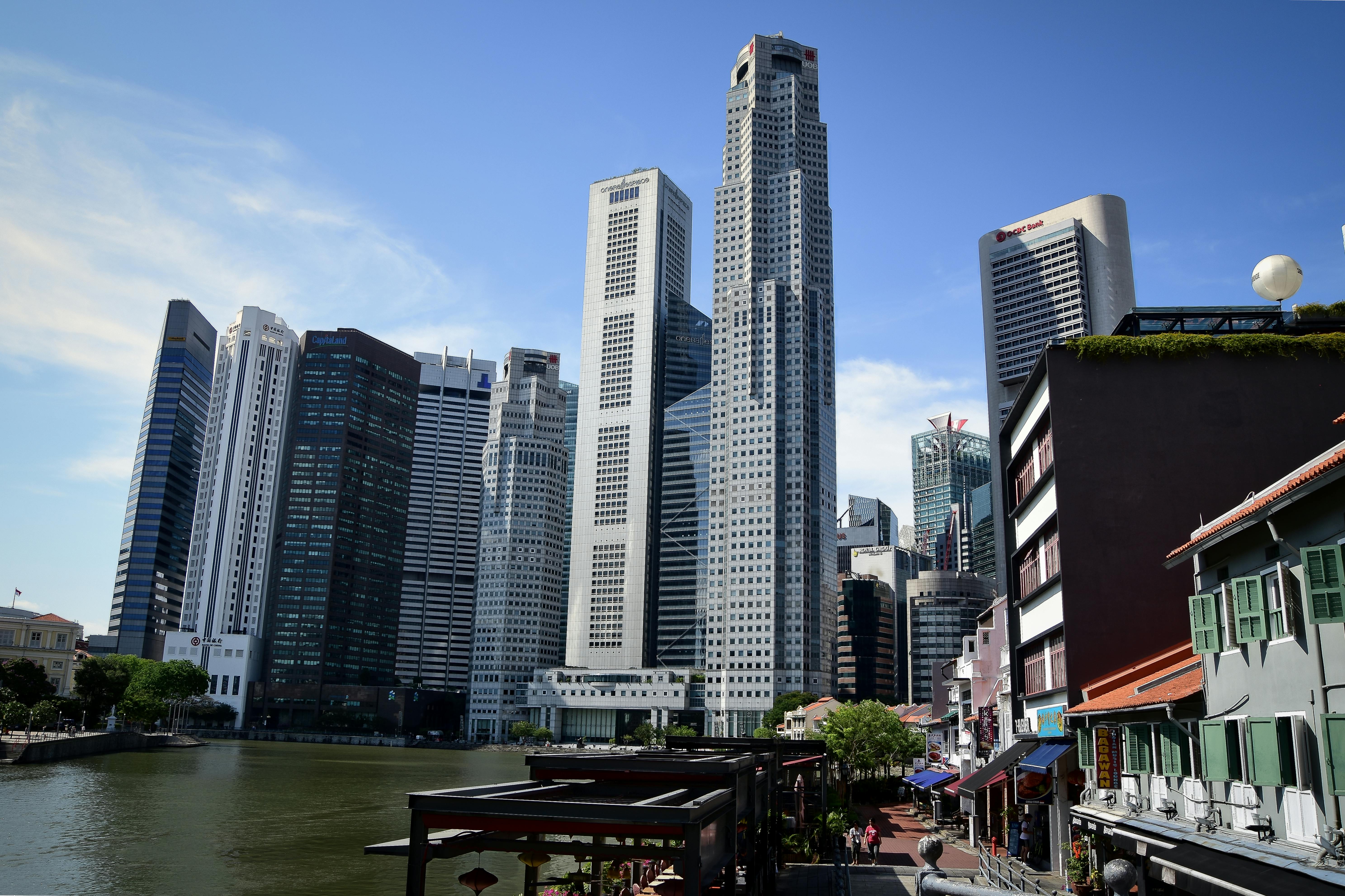 A vibrant cityscape featuring Singapore's iconic skyline with tall skyscrapers by the river.