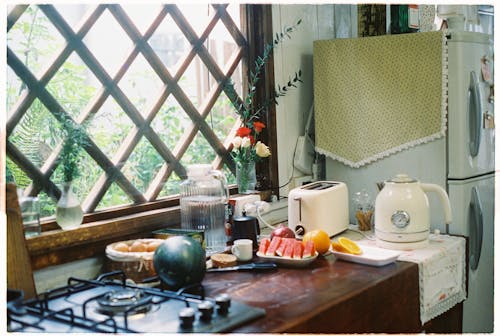 A kitchen with a stove, refrigerator, and a window