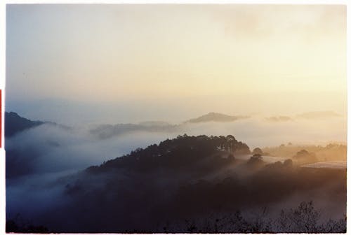 A photo of a foggy landscape with a sunset