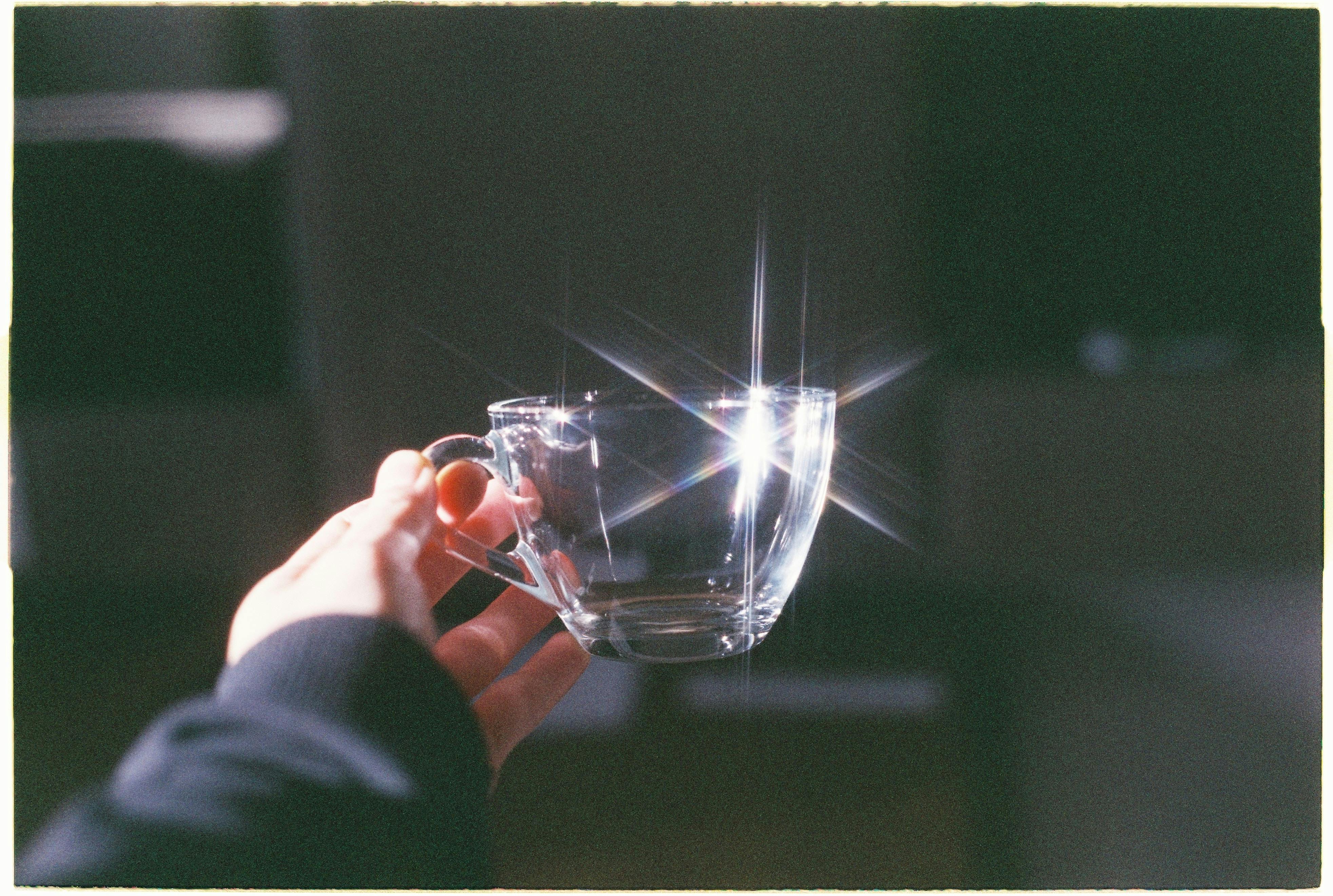 A sparkling glass mug reflects sunlight, creating a striking visual effect.