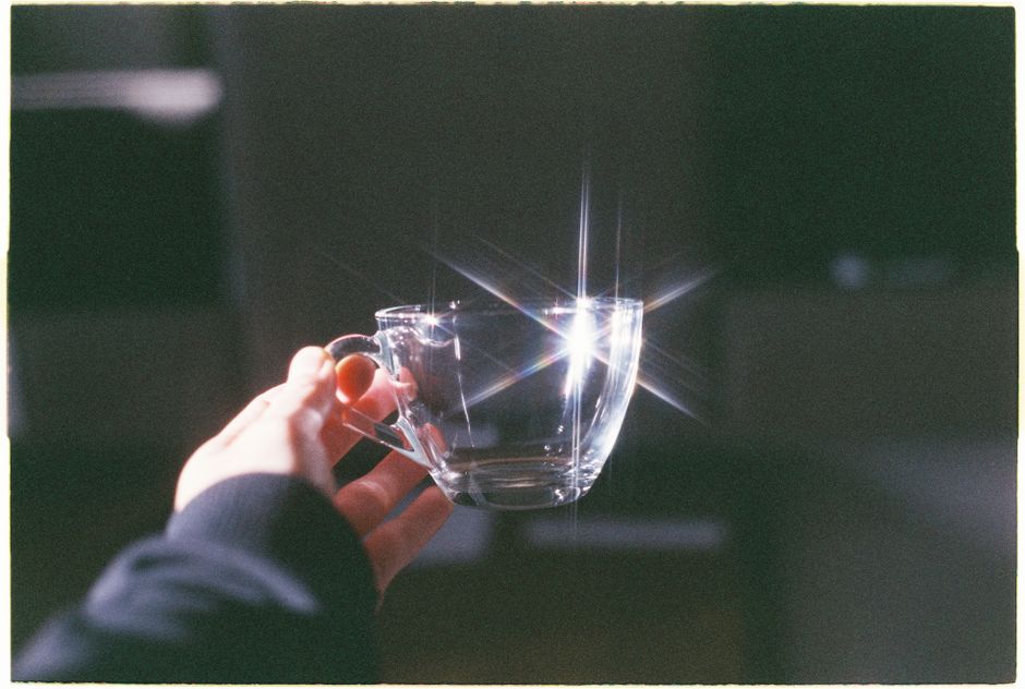 A sparkling glass mug reflects sunlight, creating a striking visual effect.