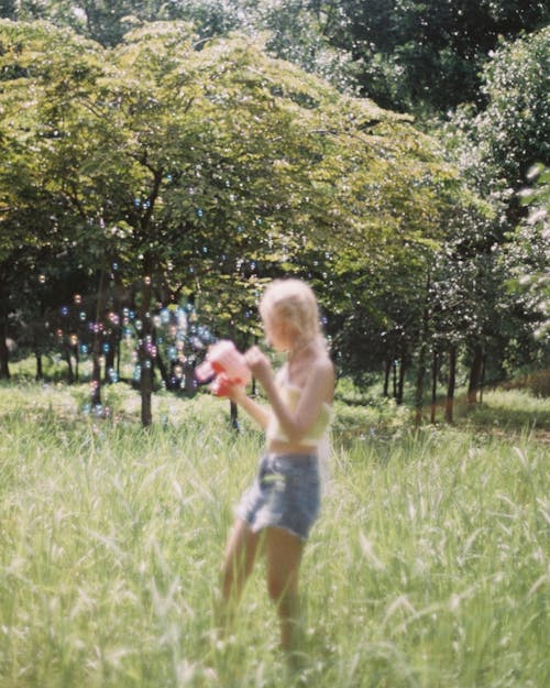 A woman in a denim shirt is playing with a ball