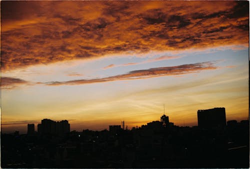 A sunset over a city skyline with clouds