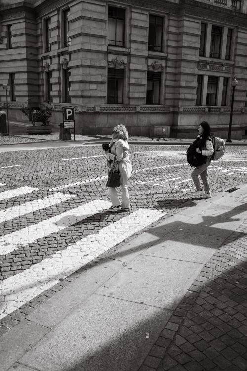 Free A lively street scene in Porto, Portugal, featuring pedestrians crossing a cobblestone street. Stock Photo