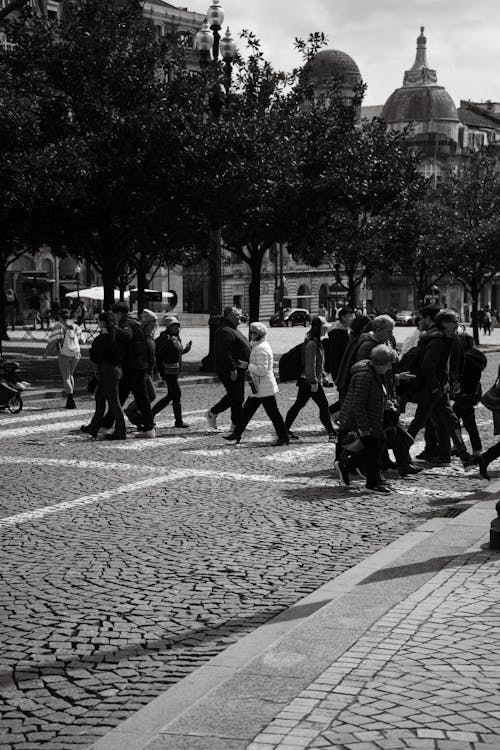 A black and white photo of people walking on the street