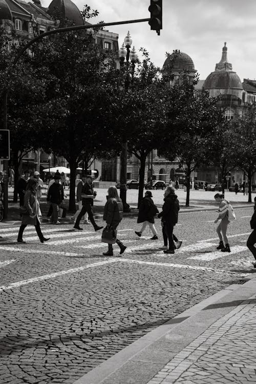 A black and white photo of people crossing the street