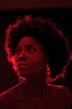 在戏剧性的红色灯光下，一位迷人的女性侧影展现出优雅