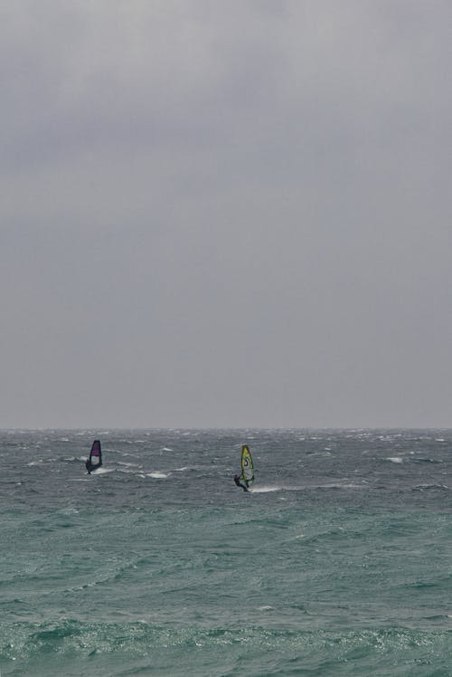 Two people windsurfing in the ocean