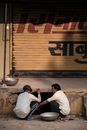 Two Man Sitting Near A Hole