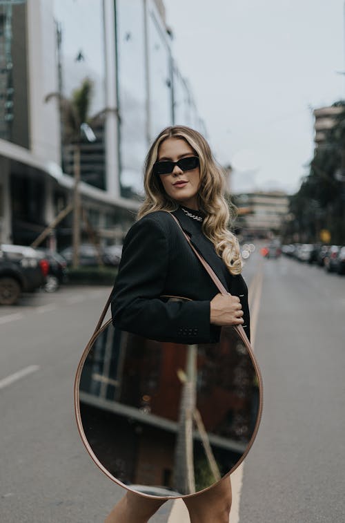 Blonde Woman in Sunglasses and with Mirror on Street