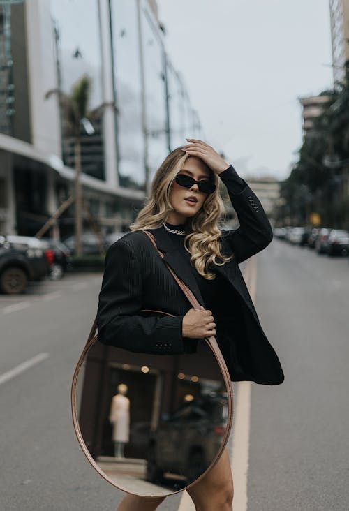 Blonde Woman Standing with Mirror on Street