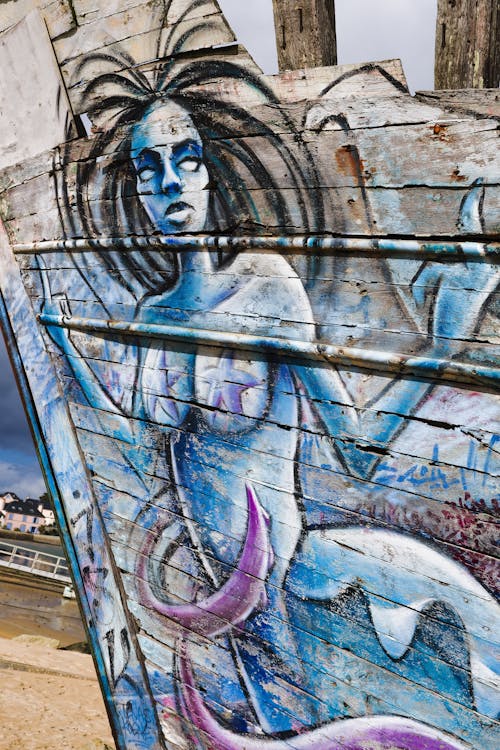 Graft of a mermaid on an old wood boat