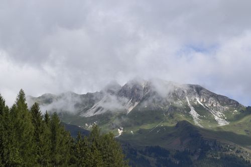 Free Stunning view of a lush green mountain range with clouds gently embracing the peaks, perfect for nature enthusiasts. Stock Photo