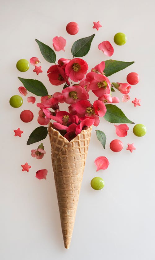 A cone filled with flowers and green leaves