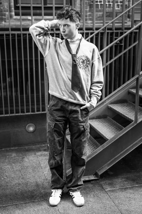 Man in Pullover and Tie Standing near Stairs