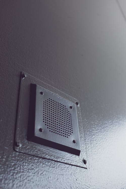 A close up of a metal speaker on a wall