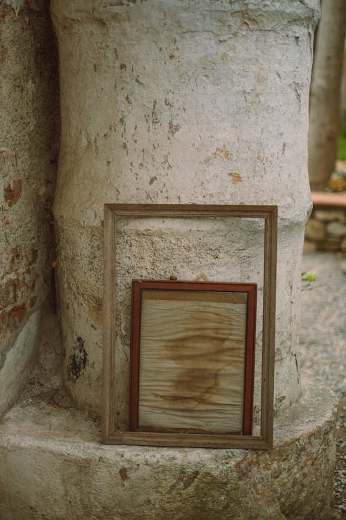 Old Picture Frames Standing next to a Concrete Column