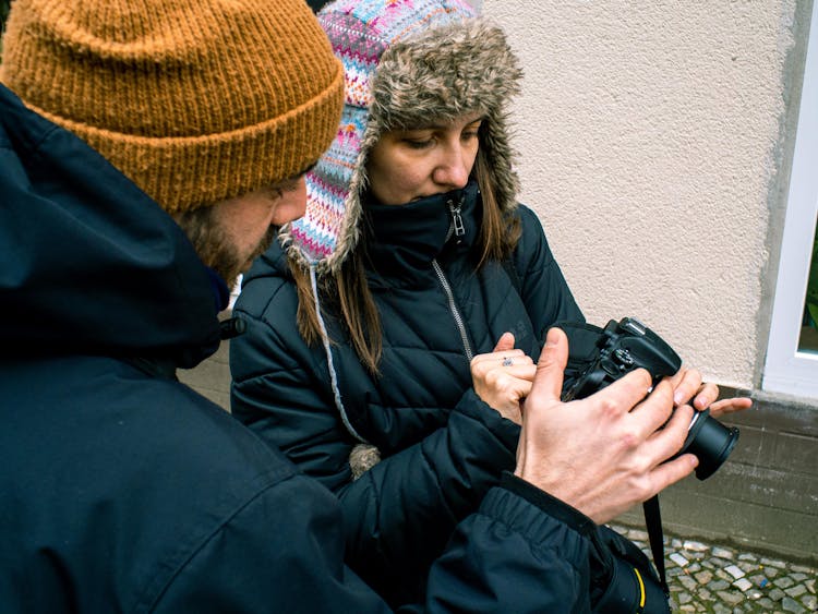 A Man And Woman Looking At The Camera Viewfinder