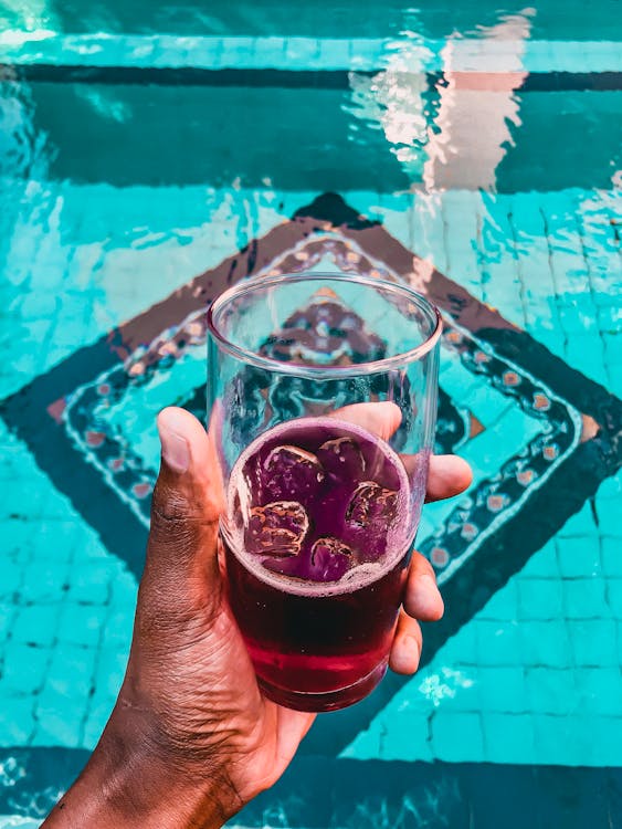 Free Person Holding Glass of Purple Beverage Stock Photo