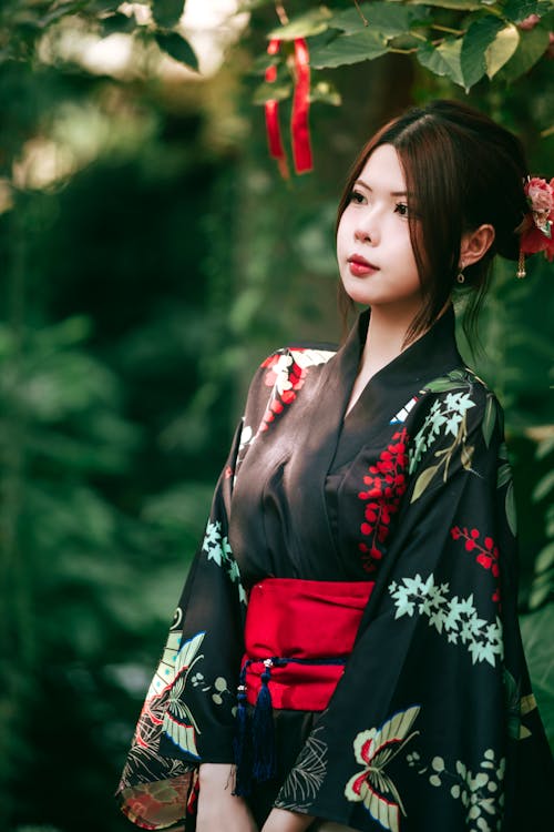 A woman in a kimono standing in the woods