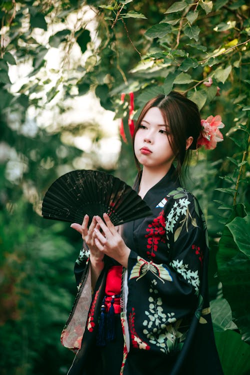 A woman in a kimono holding a fan