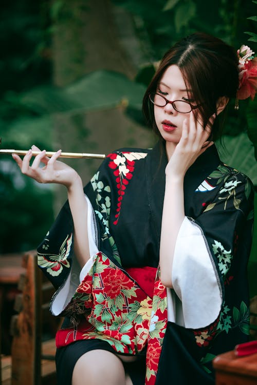 A woman in a kimono holding a chopstick