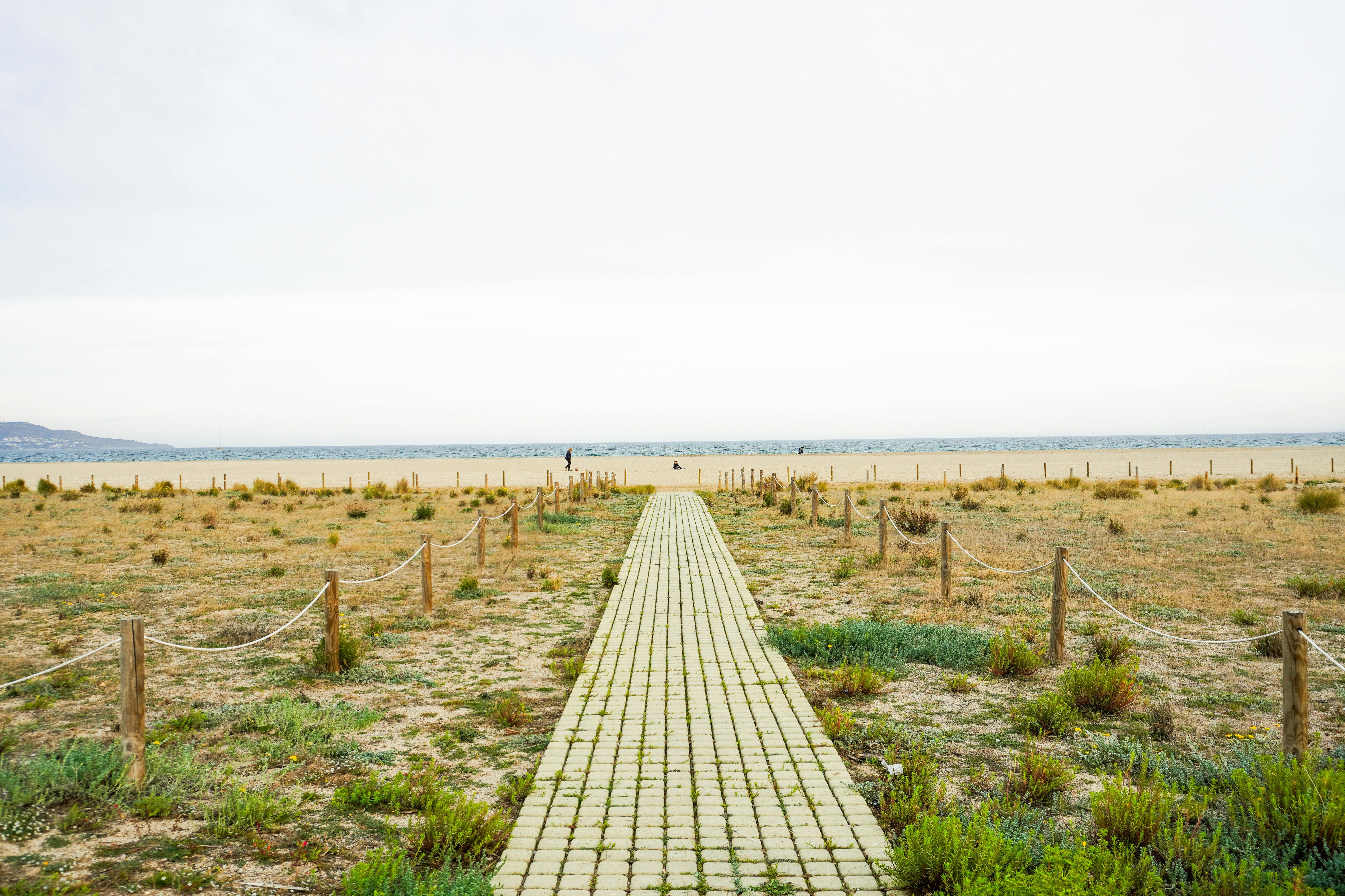 Scenic beach pathway leading to the tranquil sea in Ampuriabrava, Spain.
