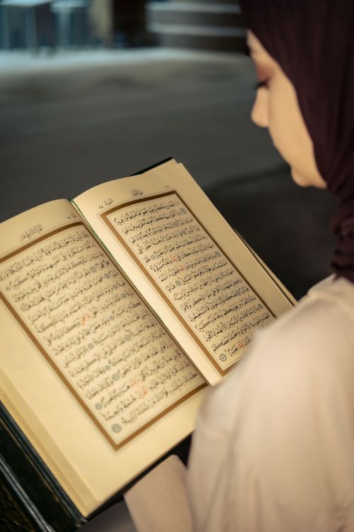 Free A woman peacefully reading the Quran, highlighting spiritual reflection and tranquility. Stock Photo