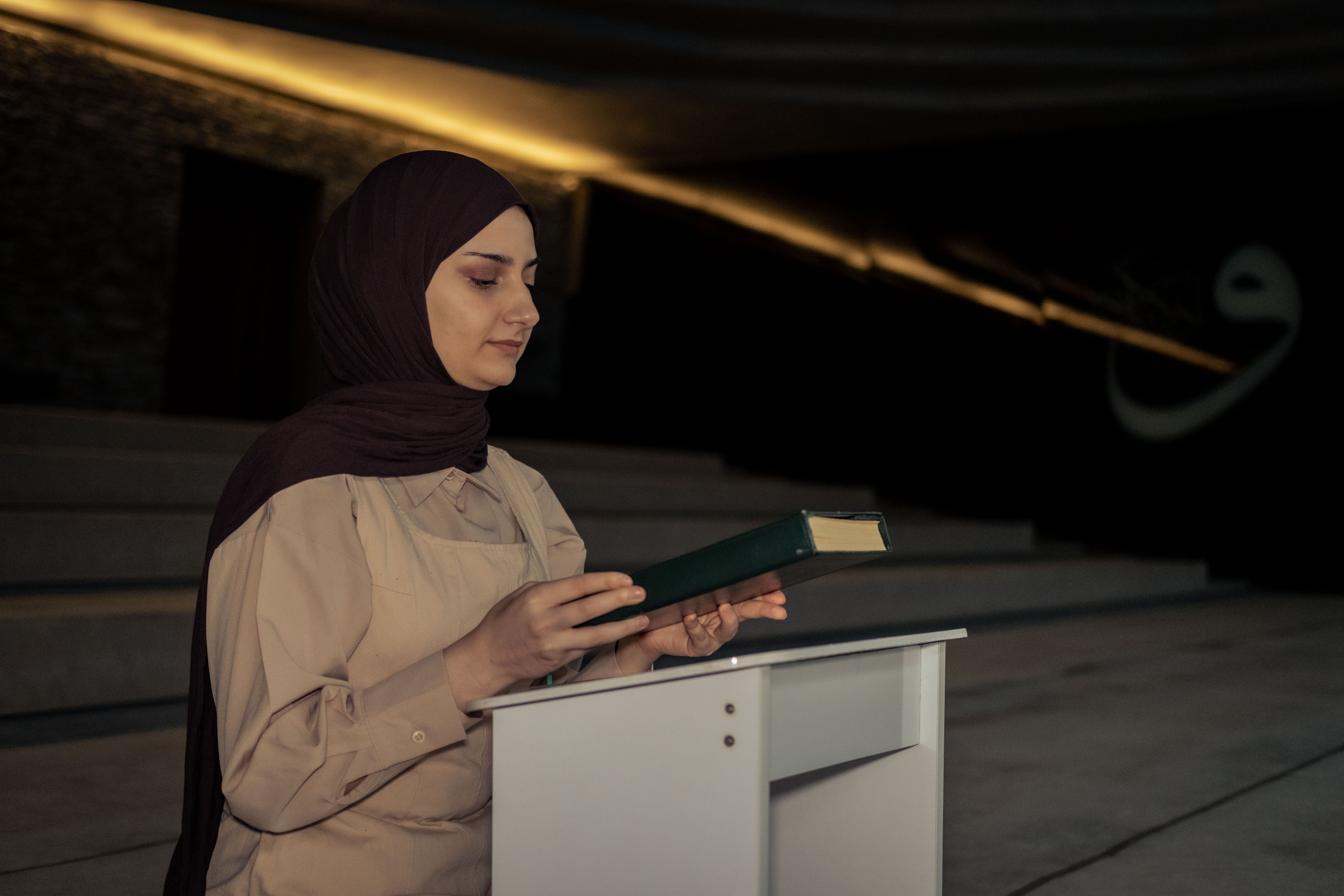 A woman in a hijab reading a book · Free Stock Photo