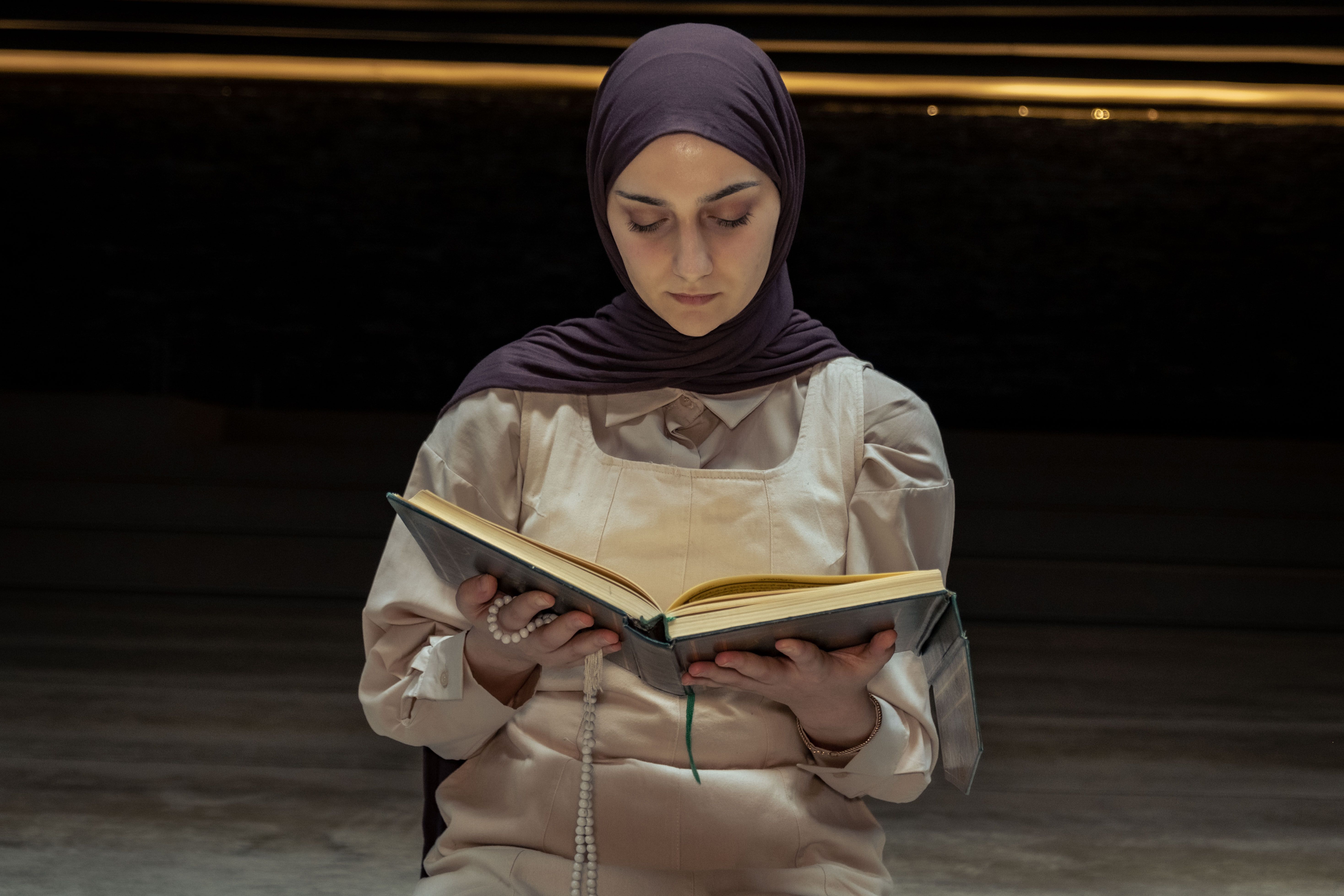 A woman in a hijab reading a book · Free Stock Photo