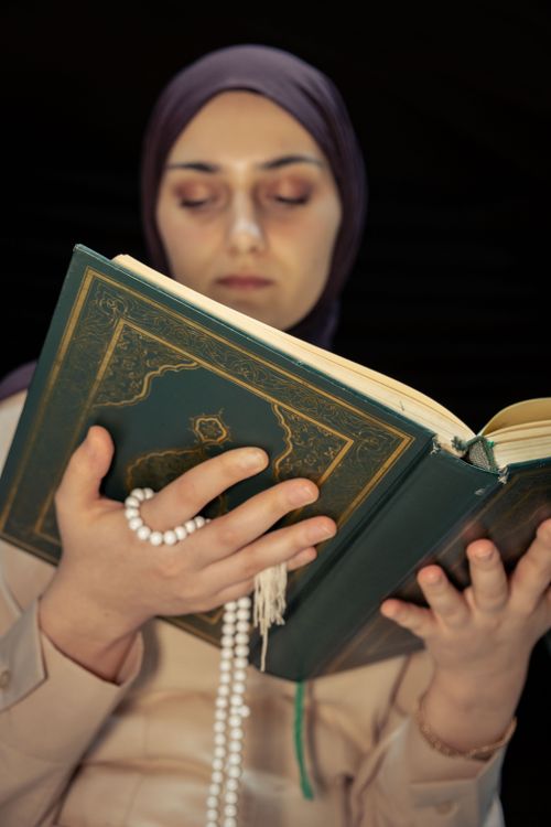 A Woman in Black Hijab Holding a Blue Quran Book · Free Stock Photo