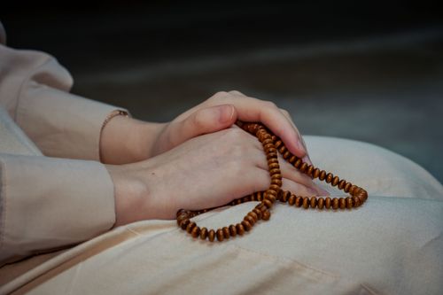 Free Close-up of hands holding wooden prayer beads, symbolizing spirituality and meditation. Stock Photo