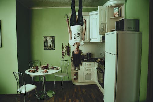 Woman Standing on Ceiling Inside Room