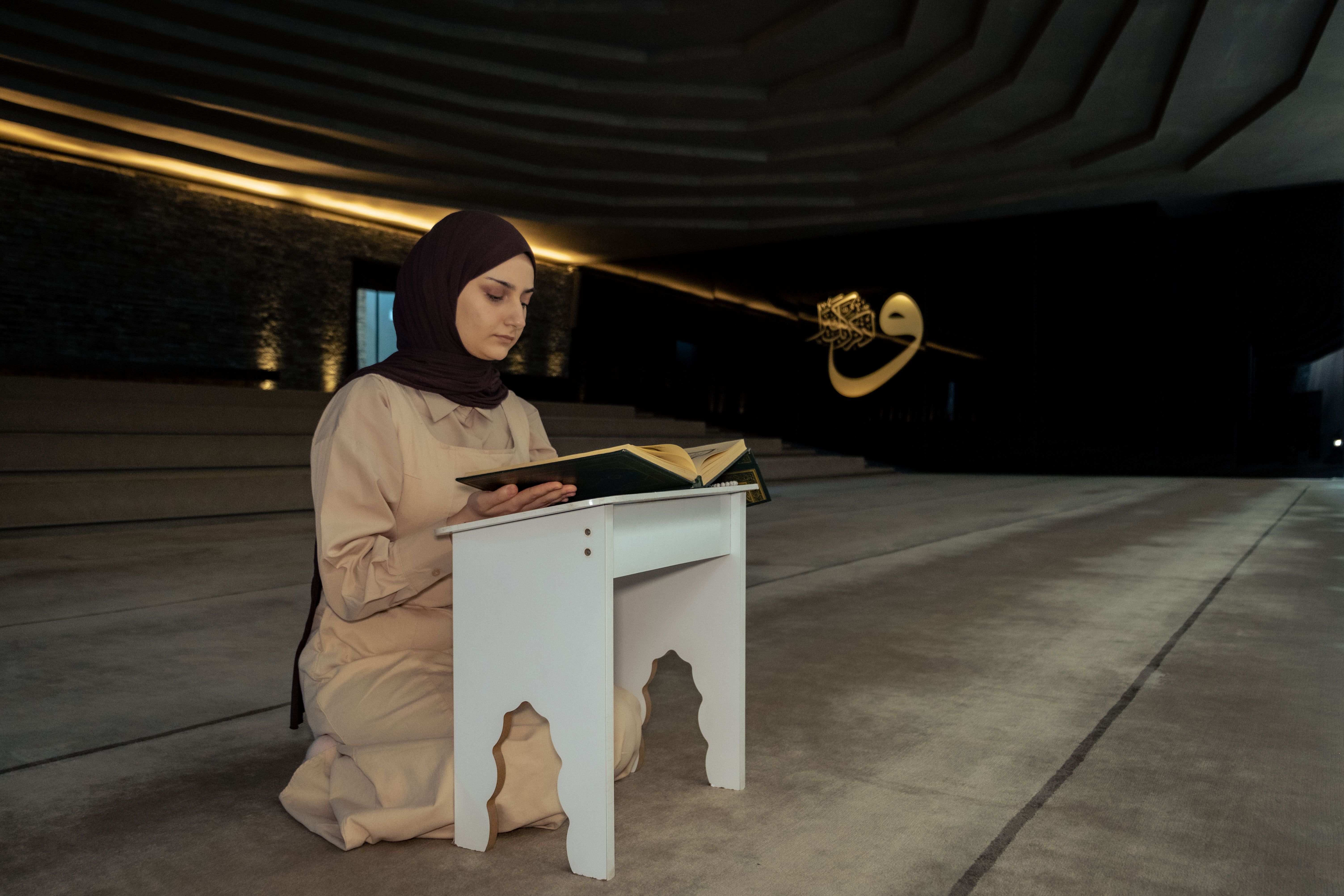 A woman in a hijab reading a book · Free Stock Photo