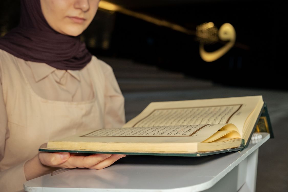 Woman in Hijab Holding Koran and Praying · Free Stock Photo