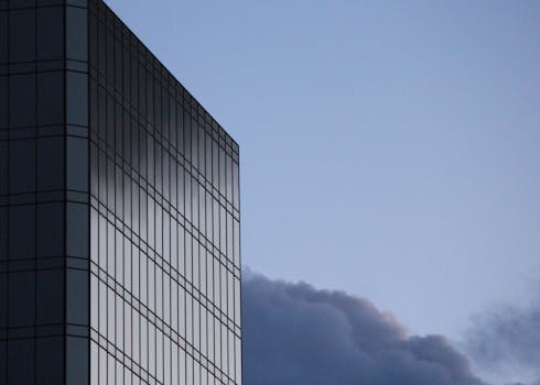 傍晚的光线在微妙的天空下映照在玻璃建筑立面上