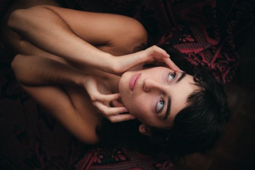 Free An intimate and artistic portrait of a woman in a thoughtful pose. Stock Photo