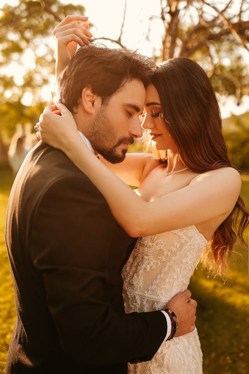 A bride and groom embrace in the sun