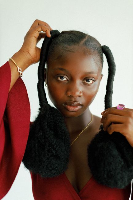 Elegant portrait of a young woman with unique hairstyle indoors.