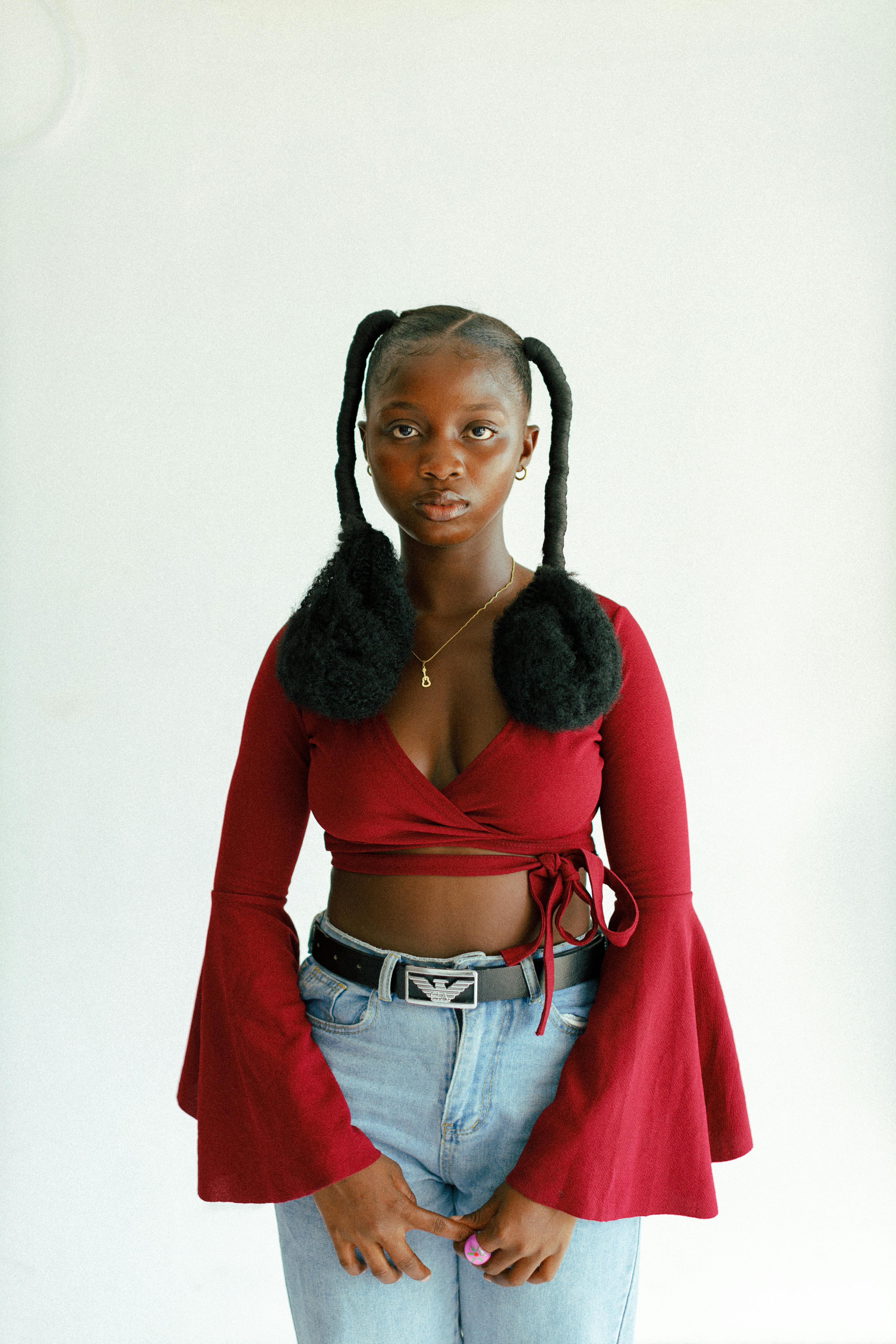 Stylish portrait of a young African American woman posing against a white background.